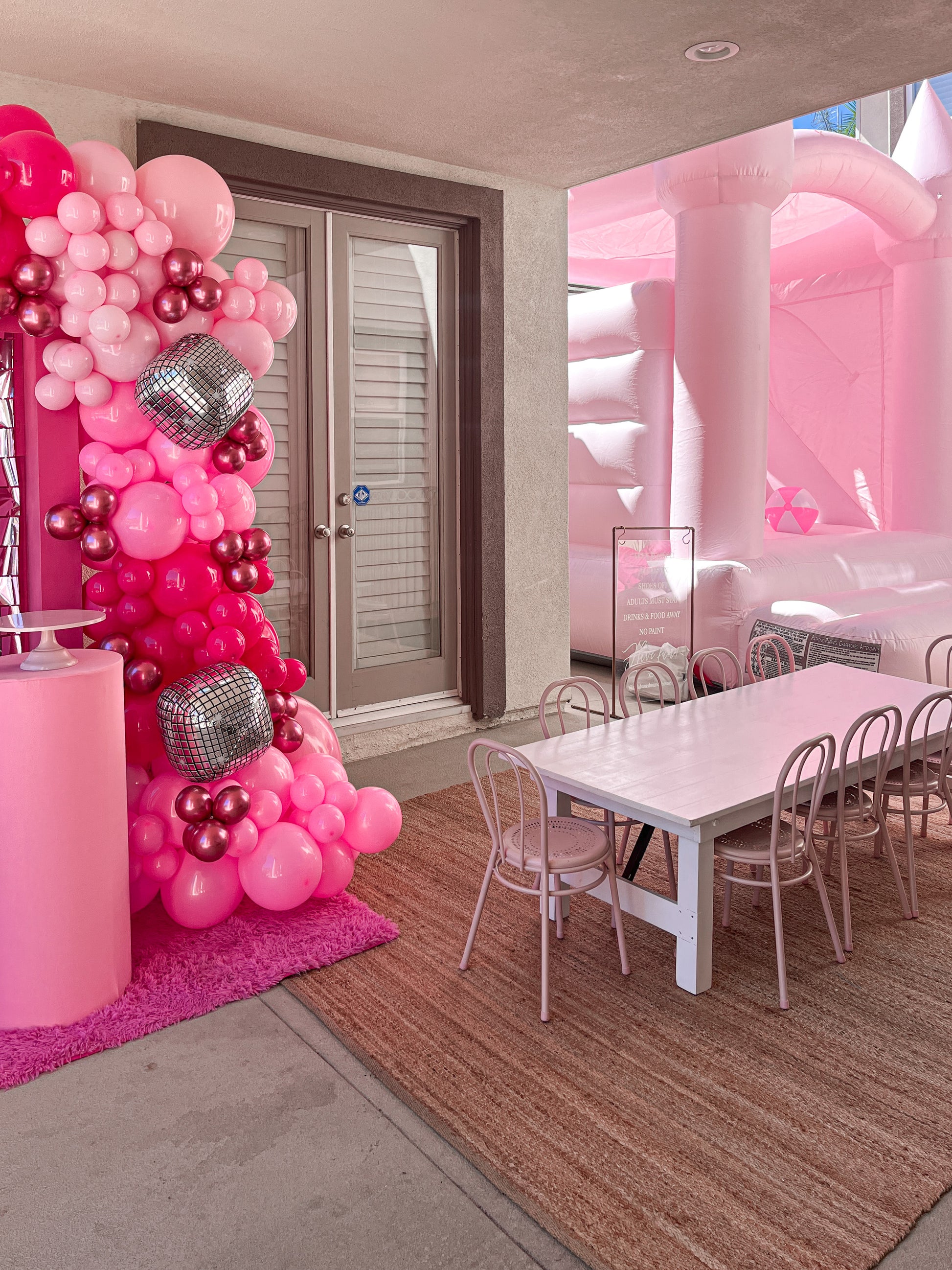 Photo of a pastel pink County Line bounce house with a slide, proudly made in America by Calabasas Bounce House.