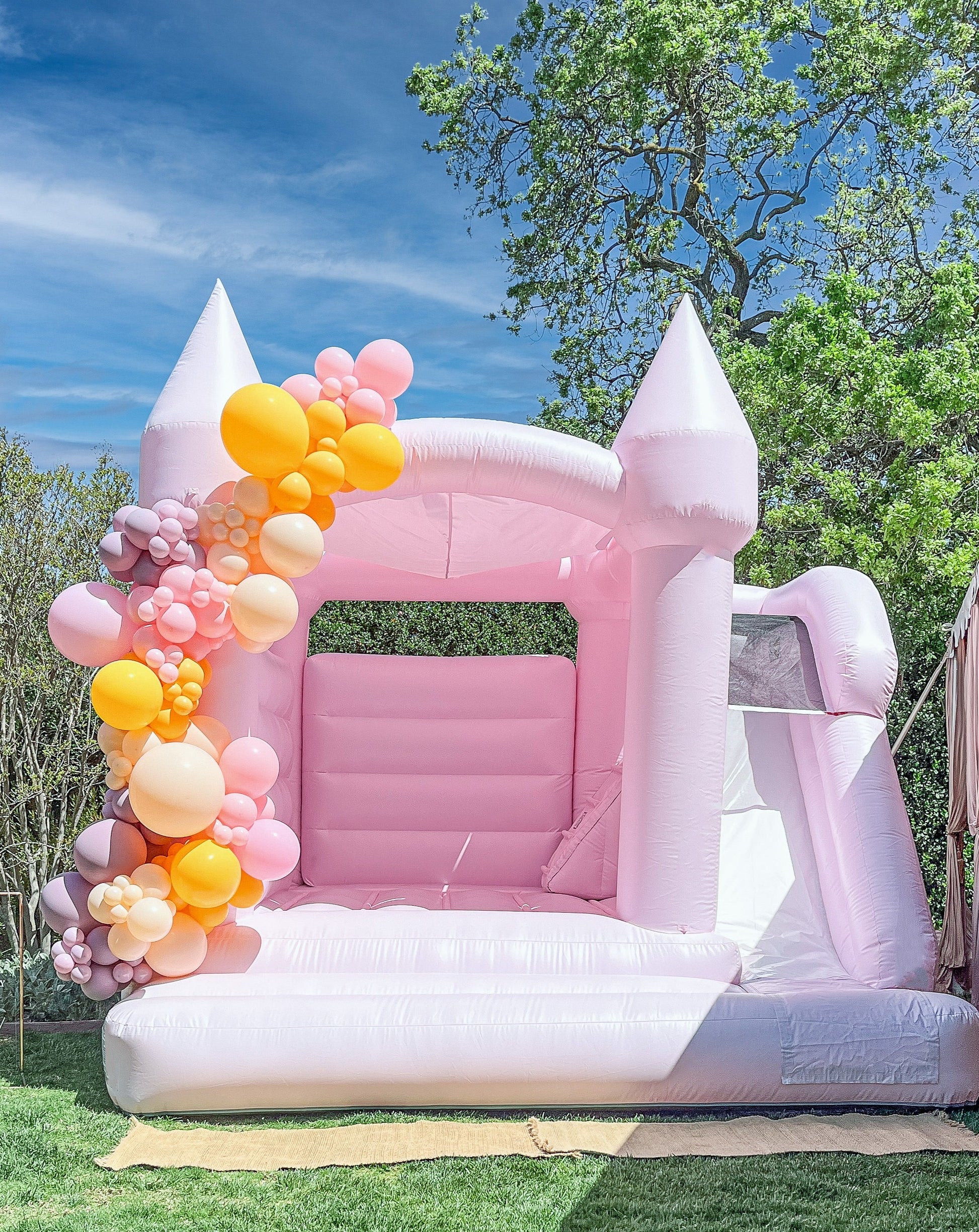 Introducing the County Line Bounce House, a unique creation resulting from our collaboration with leading US Bounce House manufacturers. Designed in a delightful pastel pink shade, this custom hybrid bounce house pays homage to the iconic and last surf spot in Malibu. With an added slide feature, the County Line Bounce House shares the stunning similarities with our popular Malibu Bounce House.