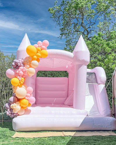 Introducing the County Line Bounce House, a unique creation resulting from our collaboration with leading US Bounce House manufacturers. Designed in a delightful pastel pink shade, this custom hybrid bounce house pays homage to the iconic and last surf spot in Malibu. With an added slide feature, the County Line Bounce House shares the stunning similarities with our popular Malibu Bounce House.
