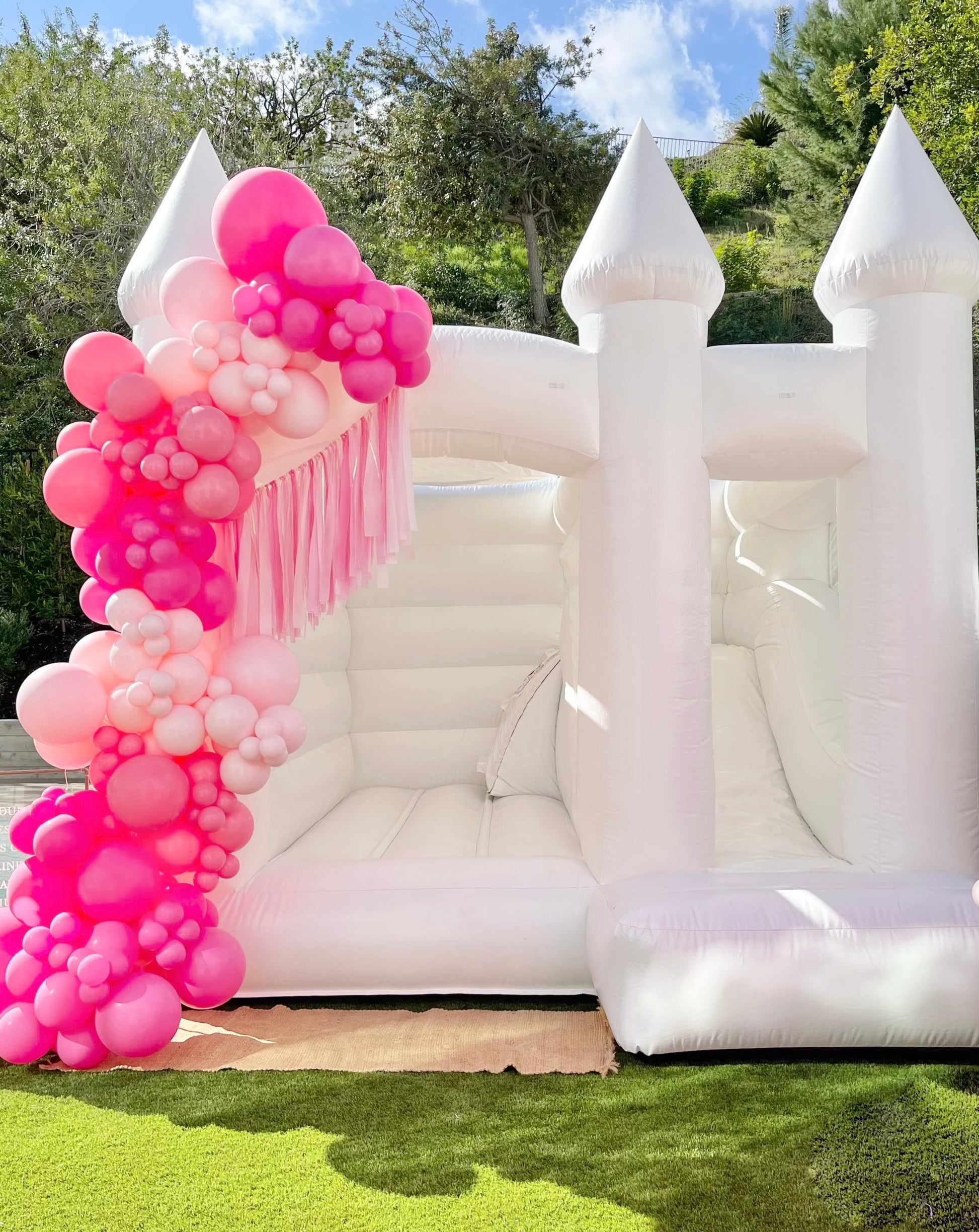 This made-in-America Bounce House stands at 12x12 and is perfect for space-sensitive homes. Surfrider mini is just as magnificent and timeless as its predecessor, Malibu Bounce House with Slide, but on a smaller scale.  The new Surfrider Mini Bounce House with Slide, is a newly reimagined American made bounce house designed by the Calabasas Bounce House team.